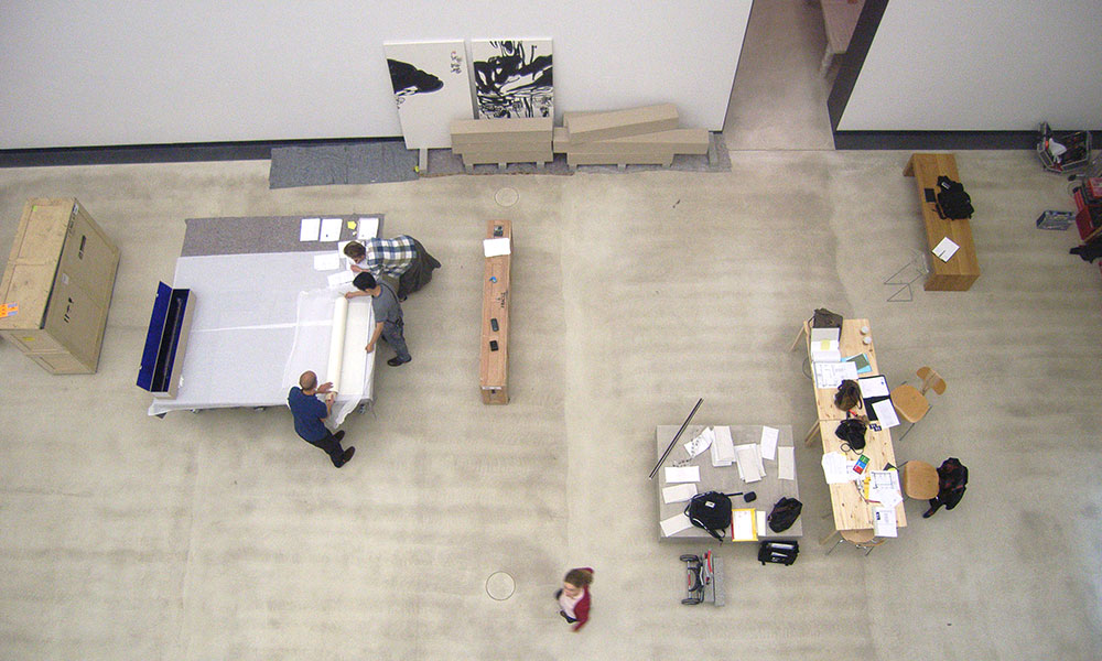 Eine Ansicht eines Raumes mit mehreren Personen, die gemeinsam an einem Projekt arbeiten.