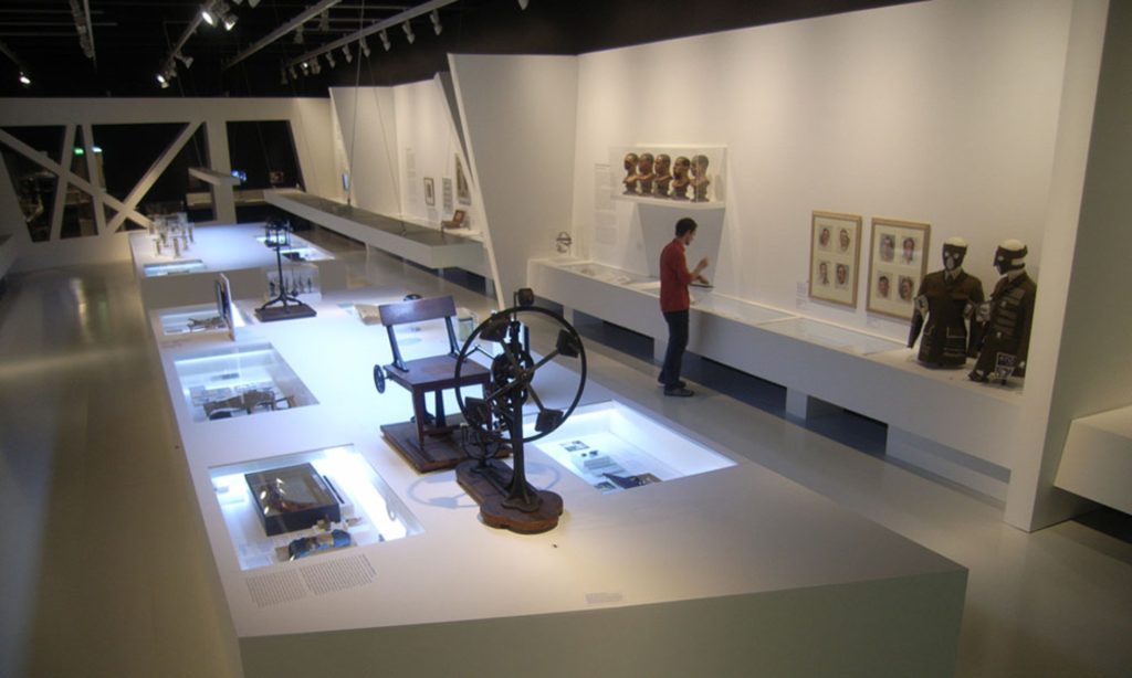 Ein Mann betrachtet eine Ausstellung von Objekten in einem Museum.